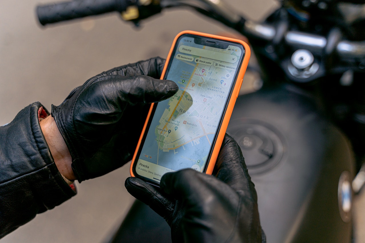 a motorcycle rider using a map on a smartphone