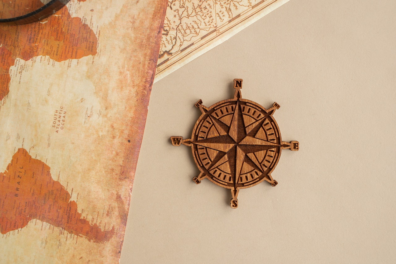 a wooden compass with worn, old maps