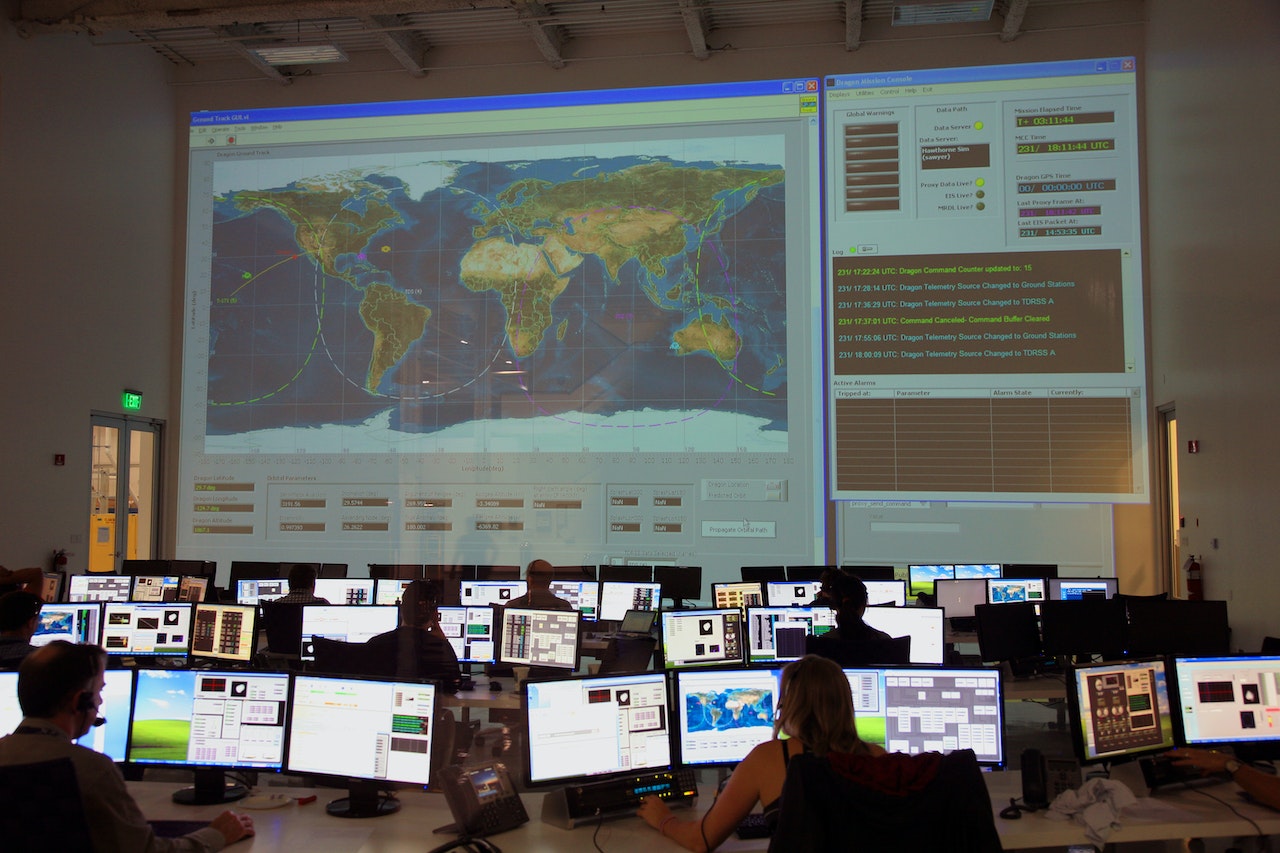 A group of colleagues analyzing data from a map on a big screen