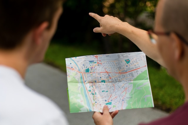 Two individuals utilizing a well-detailed paper map to navigate their surroundings.