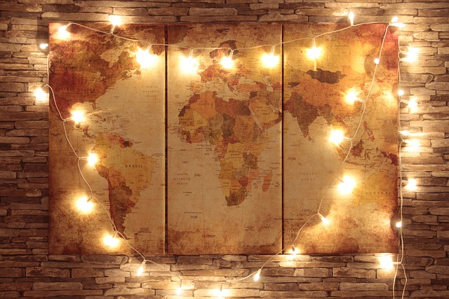 The world map on a wall with led lights surrounding it.
