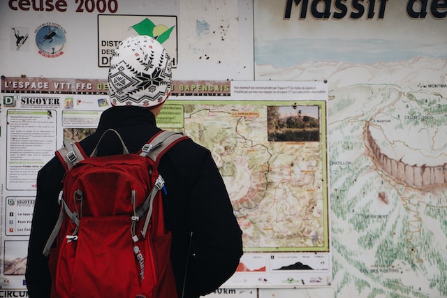 A young man checking a physical map pasted on a public notice board.