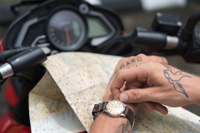 A rider setting up his watch as he prepares for a delivery trip with a physical map.