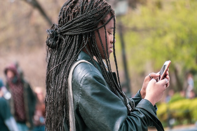 A lady checking for the fastest way home from her location via a navigation app on her smartphone.