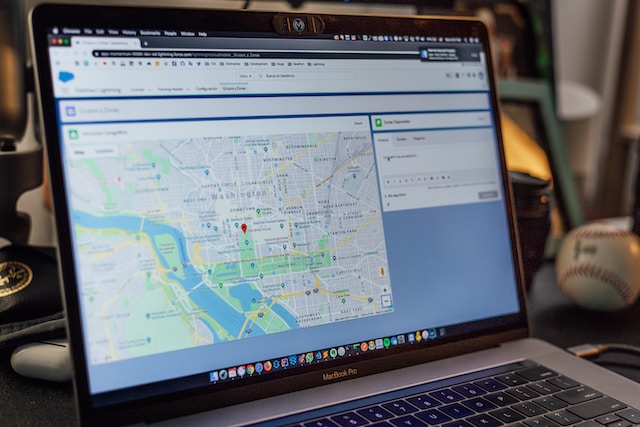 A MacBook Pro displaying the Google Maps homepage.
