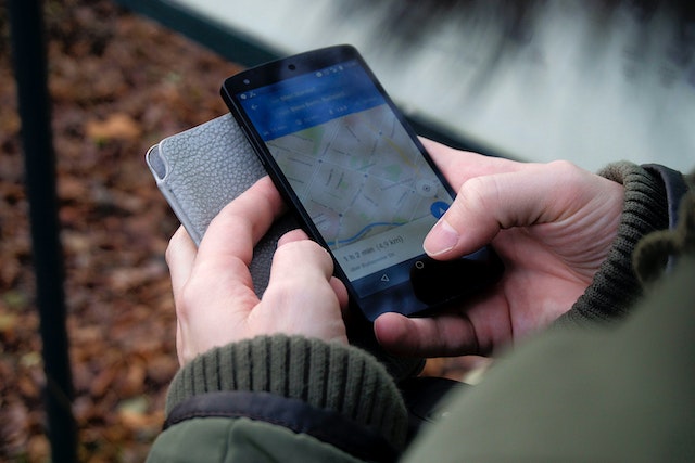 A person using the Google Maps application on a black Android smartphone.