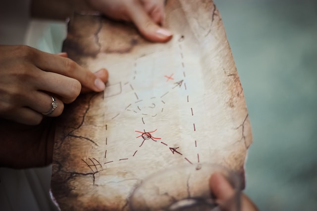 Two persons holding a map showing lines connecting different points.