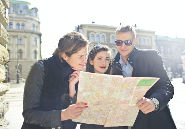 A group of three navigating the city with a physical map.