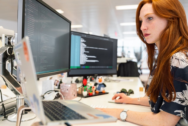 A lady using a mapping software on different PCs for business needs.