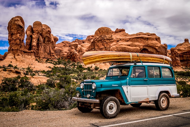 A teal and white SUV in a breathtaking landscape.