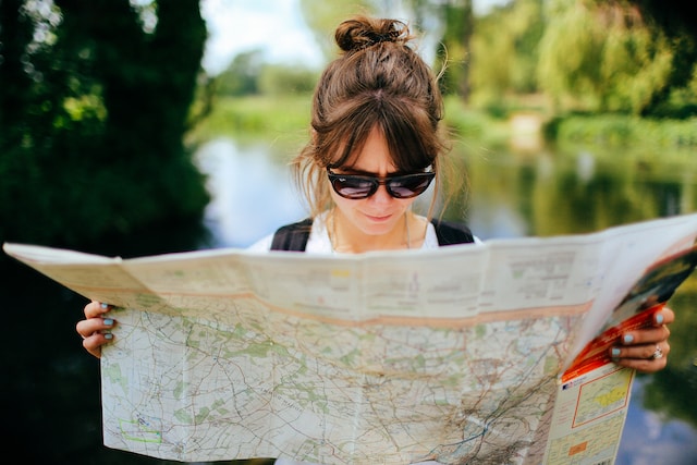 A lady checking out features on a map with symbols. 