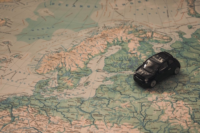 A close view of a black toy car on a physical map.