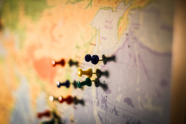 Push pins on specific locations on a physical map.