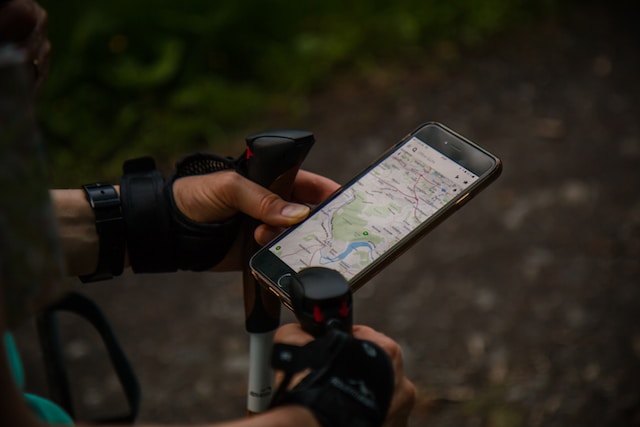 A user utilizes an online map builder while navigating the woods.