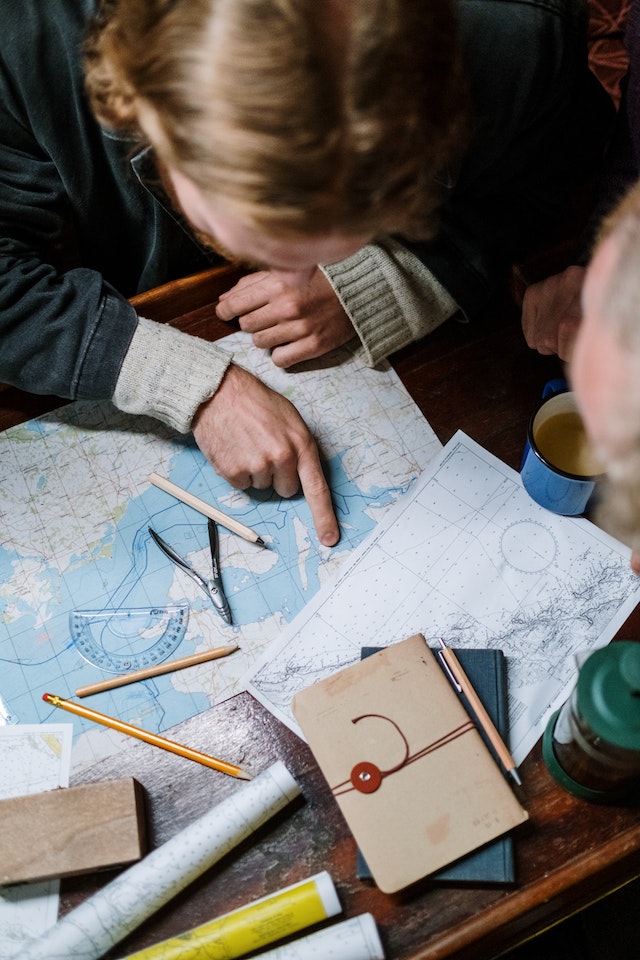 People are trying to convert geographic coordinates using a physical map manually.