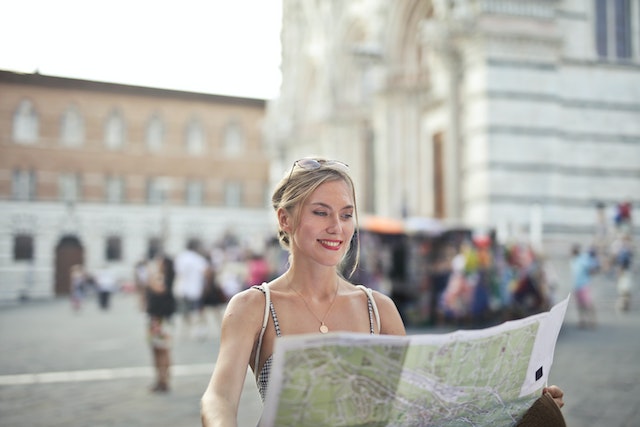 A tourist checking for the world’s biggest cities with a guide map.