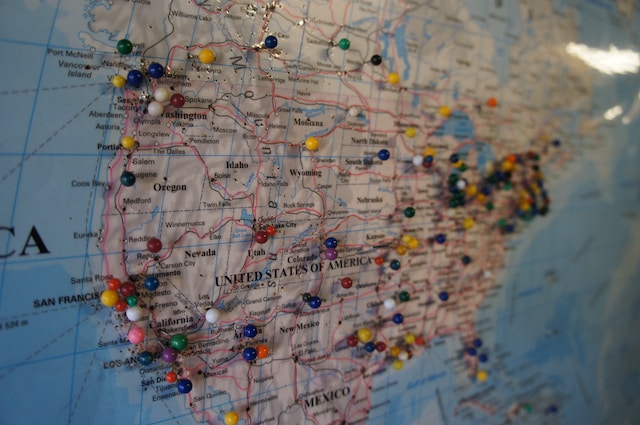 A physical map displaying pins on certain states of the USA.