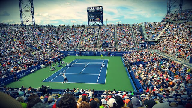 Thousands of fans enjoying a spirited tennis game. 