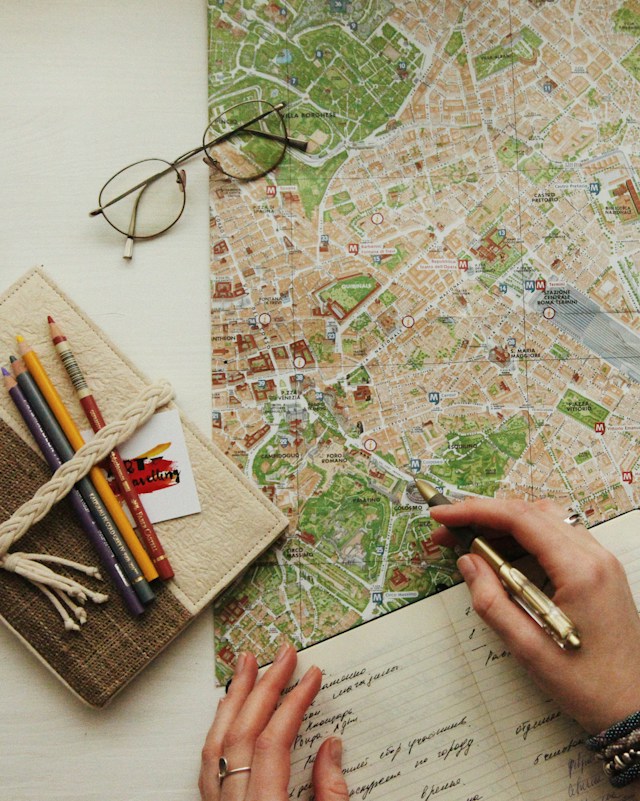 A cartographer manually plots geographical coordinates on a map.